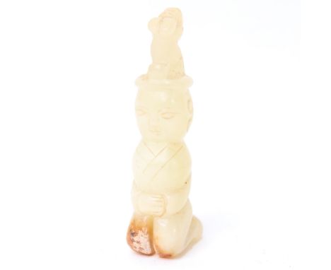 A Chinese carved and polished mutton fat jade kneeling figure, height 7.5cm 