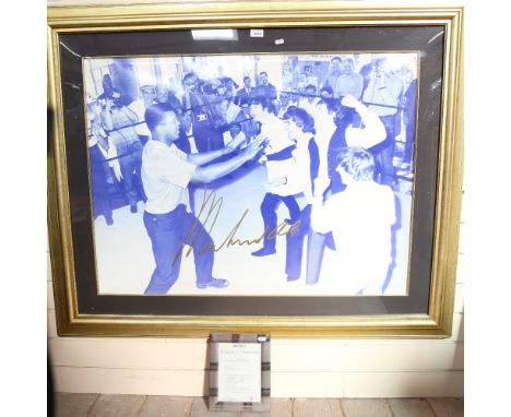 A large scale photographic print of Muhammad Ali with The Beatles, signed in pen by Ali, overall frame dimensions 104cm x 130