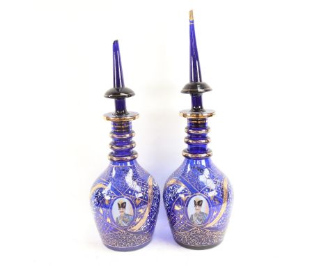 A pair of gilded blue glass Ottoman style large decanters, with portrait panels, largest height 57cm 