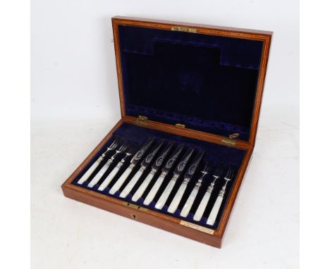 A cased set of 6 mother-of-pearl handled fruit knives and forks, with plated blades and silver collars 