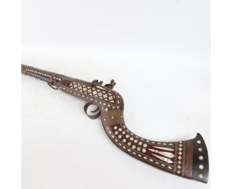 A 19th century Middle Eastern flintlock camel rifle, with allover mother-of-pearl inlaid decoration, brass strapwork and a si
