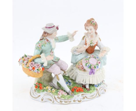 A German Sitzendorf porcelain group, seated couple with flowers, crowned S mark on base, height 14cm 