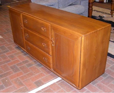 A retro Ercol Golden Dawn sideboard with three central drawers flanked by cupboards - 156cms wide