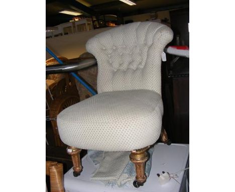 An antique button back bedroom chair on castors
