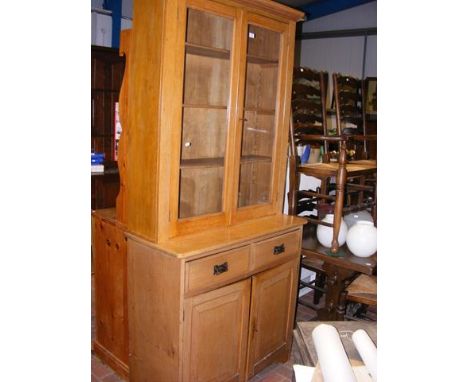 A light oak glazed bookcase on cupboard - width 97cm 