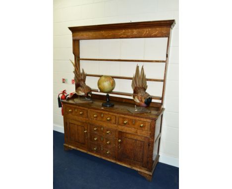 AN EARLY 19TH CENTURY OAK DRESSER, the upper section with a painted back board, three shelf boarded rack, the base fitted wit