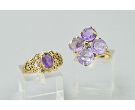 TWO AMETHYST RINGS, the first designed as an oval amethyst within a collet setting to the tapered scrolling openwork shoulder