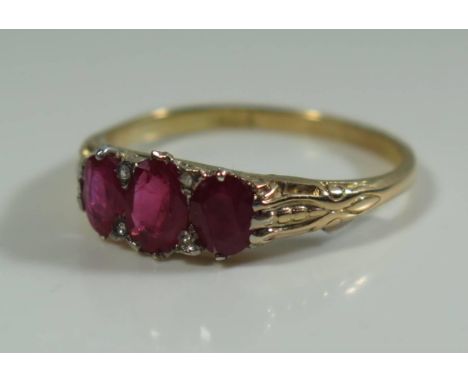 A Three Stone Ruby and Diamond Ring in 18ct yellow gold setting, size P.5, 3.1g 