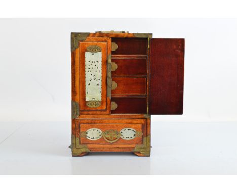 An Asian hardwood and Bowenite cabinet, of rectangular shape with fitted drawers, behind a pair of panel doors, and frieze lo