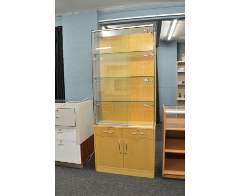 A display cabinet, having sliding glass doors to three glass shelf upper section over two drawers with cupboards under to bas