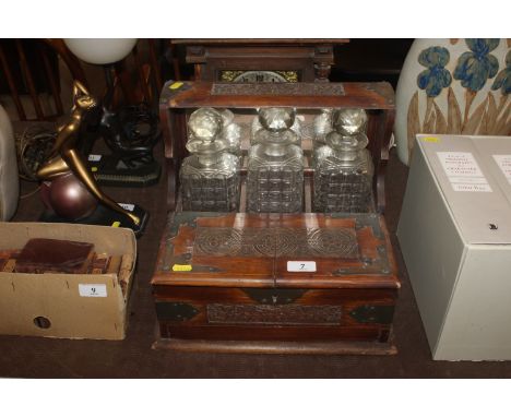 An oak and metal mounted three bottle Tantalus 