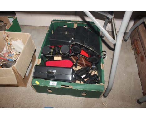 A box containing Miranda 8x40 binoculars with case, cine camera, and various other cameras and binoculars 