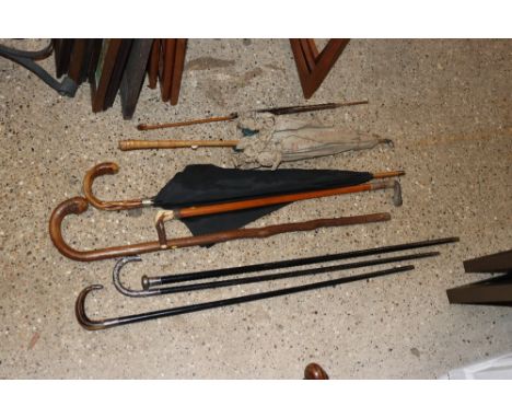 A silver topped and ebonised walking cane; an Oriental white metal handled walking stick with dragon decoration; a horn handl