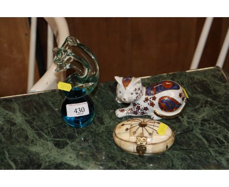 A Mdina glass paperweight; a Royal Crown Derby style model cat; and an oval trinket box 