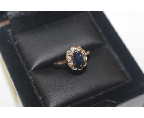 A 9ct gold ring set with cabochon blue stone surrounded by white stones, ring size N/O, approx. 2.8gms total weight 