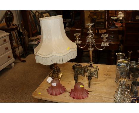 A silver plate on copper three branch candelabra; a pair of brass wall lights with cranberry tinted shades and a brass table 