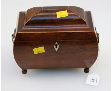 An early 19th century rosewood tea caddy of bombe form, with twin florally cast ring handles, horn lozenge escutcheon and twi