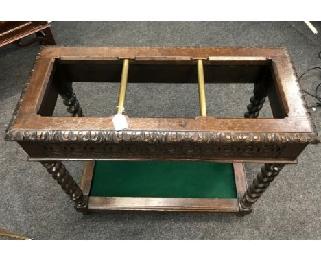 A Victorian carved oak lobby stick stand, with brass dividing rail and strapwork carving, raised on barley twist supports, 78