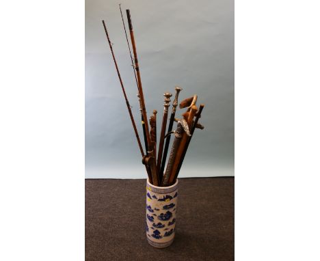 A modern blue and white cylindrical stick stand, decorated in the Chinese manner with mountains and river landscapes, contain