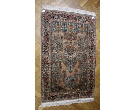 A vintage Persian silk rug, with a hanging lamp design on a peach coloured ground within floral borders, 145 x 94cm