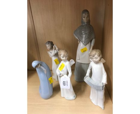 Three Nao porcelain figures of angel musicians together with a kneeling figure of the Virgin Mother and a Miquel Requena porc