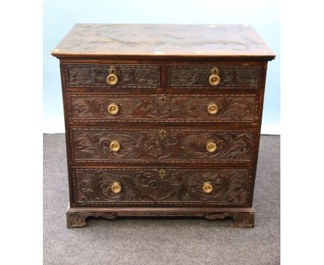 A George III oak chest of two short and three graduated long drawers, with florally cast brass formal knop handles, later all