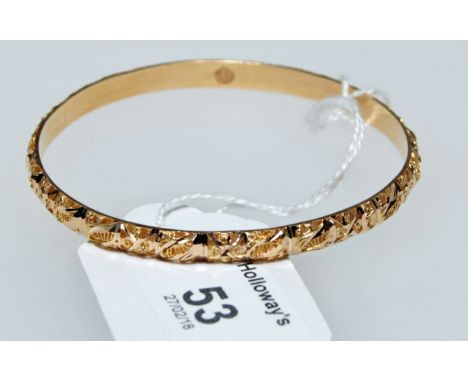 An engraved yellow gold bangle