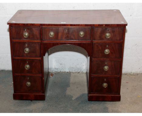 A 19th century mahogany pedestal kneehole desk, the ebony strung rectangular top over an arrangement of nine drawers with bra