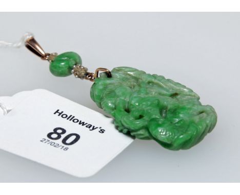 A carved jade pendant depicting mythical sea creatures, to a yellow metal, jade and seed pearl drop