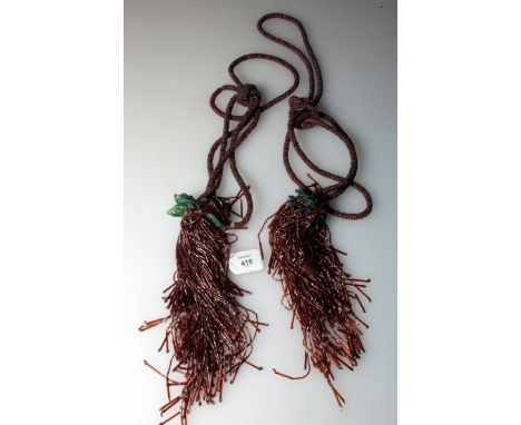 A pair of early 20th century French lustred glass bead curtain tie backs, with decorative tasselled ends