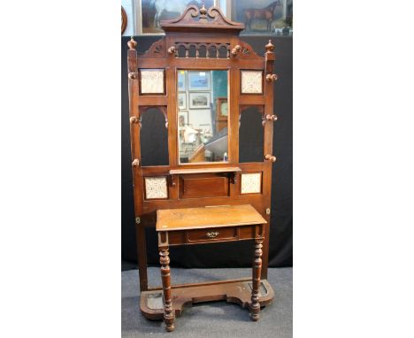 A late Victorian oak mirror and tile back hallstand, with central drawer and turned wood hat and coat pegs, 107cm wide