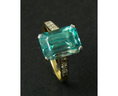 An Art Deco blue zircon and diamond ring, the step cut, cut cornered zircon in simple claw mount, to three stone diamond shou