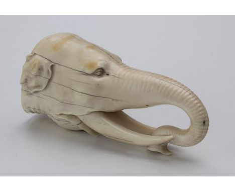 A Japanese Meiji period carved ivory okimono of an elephants head with curled trunk,14cm long