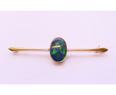 A 15 ct gold black opal bar brooch.  6.5 cm long, opal 1.5 cm x 1 cm.  4.6 grammes.