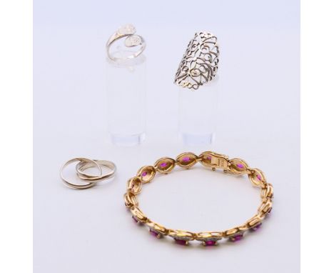 Three silver rings and a silver gilt dress bracelet. Pierced ring size L, triple ring size L, bracelet 19 cm long. 