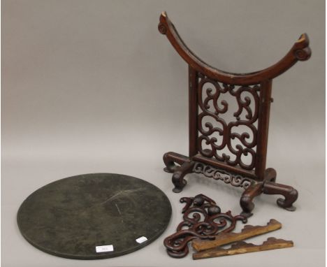 A 19th century Chinese bronze mirror on a carved hardwood stand. 39 cm diameter.