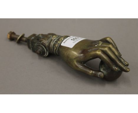 A Victorian brass door knocker in the form of a hand. 16 cm long.