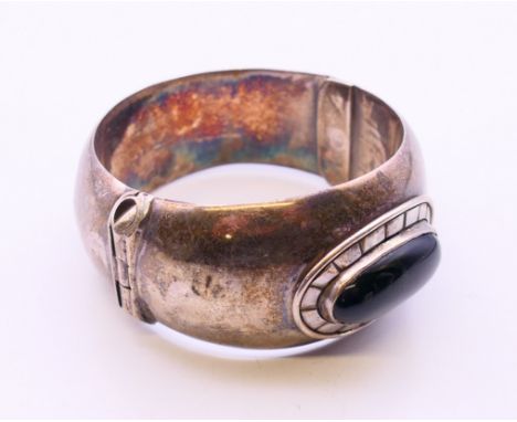 An onyx and silver bracelet.  Internal diameter 5 cm. 5.5 cm wide, 6 cm wide front to back.