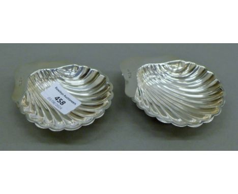 A pair of silver shell-formed salts. Each 8.5 cm wide. 93.9 grammes.