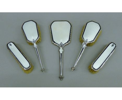 An enamel-decorated silver dressing table set. The hand mirror 27 cm high.