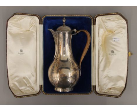 A Georgian silver hot water jug, housed in a Spink & Son later plush-lined leather case. 29 cm high. 16.6 troy ounces total w