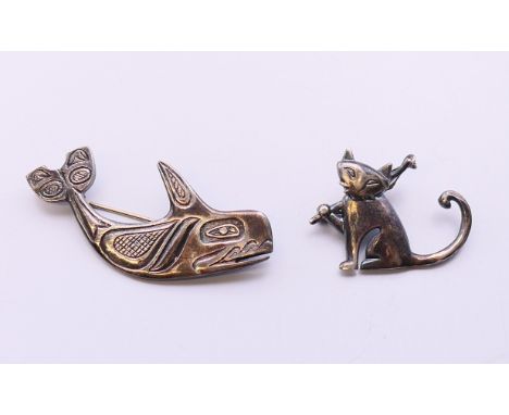 Two silver brooches, one formed as a whale, the other a cat.  Whale 6 cm x 2.5 cm, cat 2.5 cm high. 