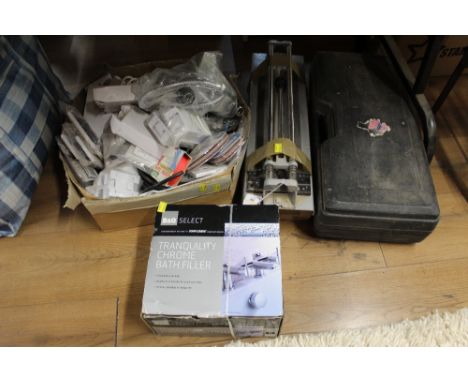 A box of Tranquillity chrome bath filler taps, a box of electrical fittings, a manual tile cutter, and a cased Master Mechani