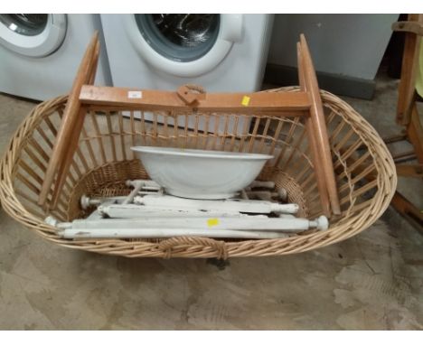 A wicker basket with base, white painted cot, and ceramic bowl 