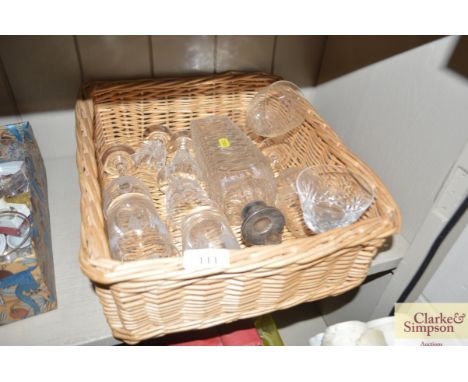 A basket containing various glassware and a silver collar decanter