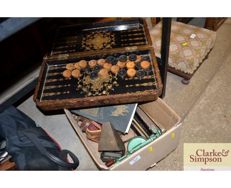 A box containing a apple peeler, a music stand, and Oriental draughts set 