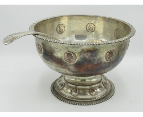 Early C20th silver plated coin set punch bowl, with gadrooned edge on circular pedestal foot, and an Old English pattern ladl