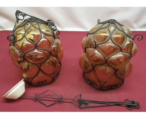Pair of contemporary bubble glass amber tinted hanging lamp shades with wire work skeletal molding and hanging brackets 
