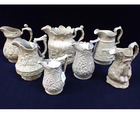 A LARGE BUFF POTTERY WOODLAND RELIEF-MOULDED JUG and six other buff jugs, Brownfield and other makers (7)