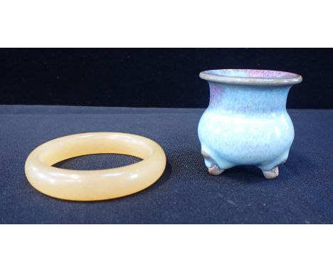 A CHINESE PALE STONE OR 'JADE' RING 8cm dia, and a small glazed three-footed pot 6cm high (2)